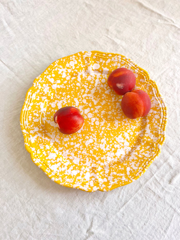 yellow and white round spatterware platter 14" on table
