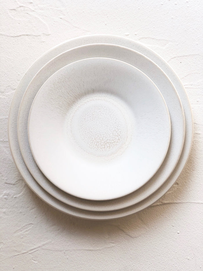 dinner plate with white on white reactive glaze 10.5 inches diameter stacked with charger and salad plate