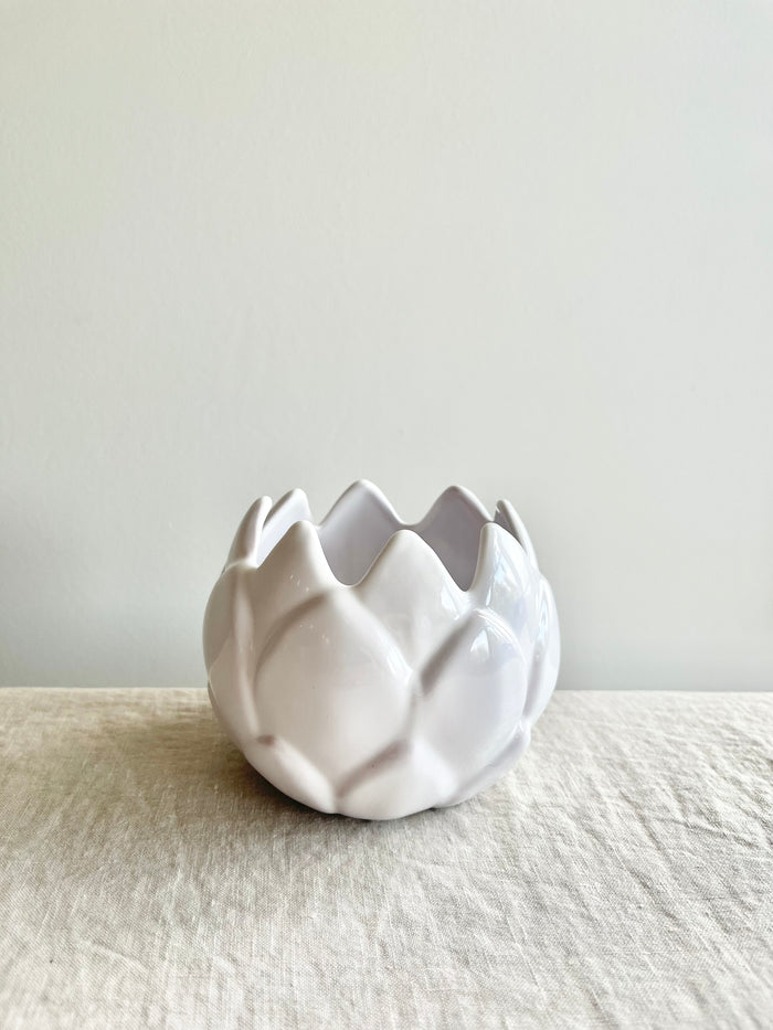white artichoke candle holder on white table