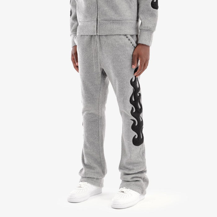 Copper Rivet Saints gray mohair pearl stacked sweat pants with a relaxed fit and ribbed cuffs, displayed on a hanger.